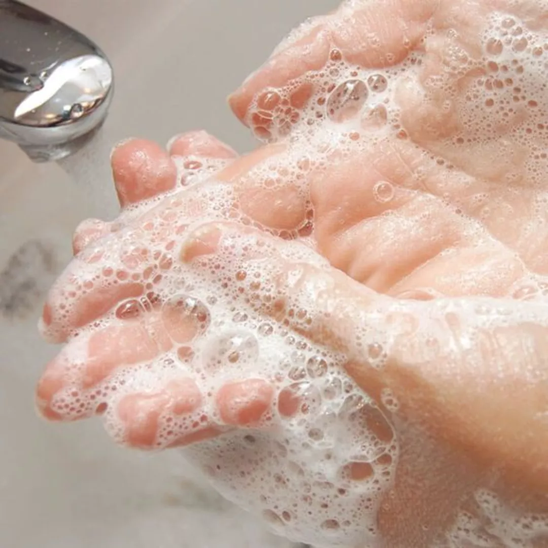 Женщина моет руки жидким мылом
