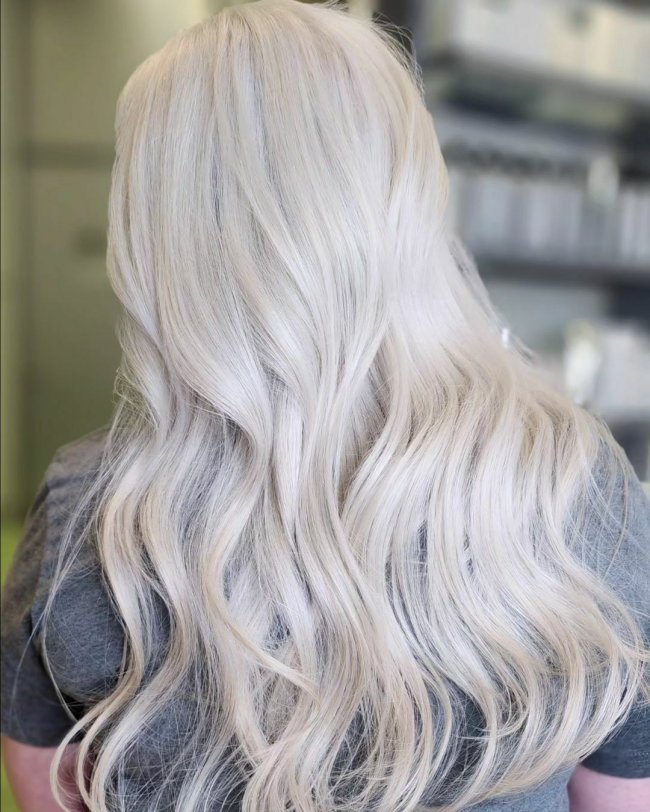 Длинные волнистые волосы платинового блонда.